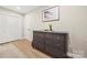 Bedroom featuring dresser and closet, with wood grain vinyl flooring and natural light coming through the window at 4820 Valley Stream Rd, Charlotte, NC 28209