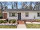 The front exterior features a white exterior, gray accents, and a welcoming brick pathway at 4820 Valley Stream Rd, Charlotte, NC 28209
