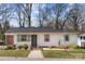 Charming single-story home featuring a white exterior, gray accents, and a welcoming brick pathway at 4820 Valley Stream Rd, Charlotte, NC 28209