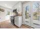 Well-lit kitchen with modern appliances, white cabinets, and access to an outdoor deck area at 4820 Valley Stream Rd, Charlotte, NC 28209