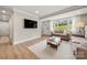 Bright and airy living room featuring hardwood floors, a large window, and comfortable sofas at 4820 Valley Stream Rd, Charlotte, NC 28209