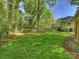 Lush green backyard showcasing mature trees, manicured lawn, and the house at 4830 Broad Hollow Dr, Charlotte, NC 28226