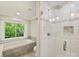 Luxurious bathroom featuring a large tub, separate shower, and window with lush views at 4830 Broad Hollow Dr, Charlotte, NC 28226