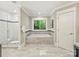 A bright bathroom featuring a soaking tub, glass shower, and tiled surround at 4830 Broad Hollow Dr, Charlotte, NC 28226