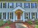 Inviting front entrance with brick walk, wood door, classic pillars, and lovely landscaping at 4830 Broad Hollow Dr, Charlotte, NC 28226