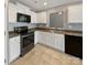 Well-lit kitchen featuring white cabinets, stainless steel appliances, tile flooring, and a convenient breakfast bar at 4906 Lynn Lee Cir, Charlotte, NC 28269