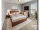 Comfortable staged main bedroom with a king bed, soft carpet, and a mounted TV for relaxation at 4906 Lynn Lee Cir, Charlotte, NC 28269