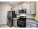 Features stainless steel appliances, granite countertops, and gray cabinets in this lovely kitchen at 522 Trading Post Ln, York, SC 29745