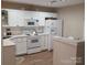 Eat-in kitchen with ample white cabinetry, stainless steel sink, and bright lighting at 5963 Moose Ln, Charlotte, NC 28269