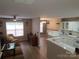 Open-concept living room with a ceiling fan and views into the updated kitchen at 5963 Moose Ln, Charlotte, NC 28269