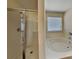 Bright bathroom featuring a glass-enclosed shower and a separate soaking tub at 600 Hunley St, Monroe, NC 28112