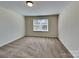 Bedroom with neutral decor, plush carpeting, and a well-lit window at 600 Hunley St, Monroe, NC 28112