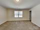 Neutral bedroom featuring a window for natural light and carpeted floors at 600 Hunley St, Monroe, NC 28112