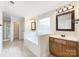 Well-lit bathroom with a large tub, double vanity, and a glass-enclosed shower at 6084 Diamond Pl, Harrisburg, NC 28075