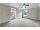 A spacious bedroom featuring neutral carpeting, and bright windows with white trim at 6084 Diamond Pl, Harrisburg, NC 28075