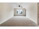 Empty bedroom with ceiling fan, large windows and plush neutral carpeting at 6084 Diamond Pl, Harrisburg, NC 28075