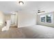 Bright bonus room featuring neutral carpeting, a ceiling fan, and large windows with natural light at 6084 Diamond Pl, Harrisburg, NC 28075