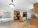 Open kitchen with tile floor, dark countertops, wood cabinets, and black appliances at 6084 Diamond Pl, Harrisburg, NC 28075