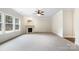 Spacious living room with fireplace, large windows, and modern ceiling fan at 6084 Diamond Pl, Harrisburg, NC 28075
