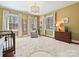 Cozy bedroom illuminated by natural light with a crib, chair, and dresser at 638 Forest Ln, Rock Hill, SC 29730