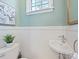 Cozy powder room with a wall-mounted sink and a flower painting at 638 Forest Ln, Rock Hill, SC 29730