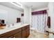 Well-lit bathroom featuring a double sink vanity and shower with decorative purple accents at 638 Nannyberry Ln, Concord, NC 28025
