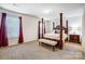 Spacious bedroom with a beautiful four-poster bed and natural light from the windows at 638 Nannyberry Ln, Concord, NC 28025