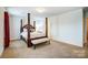 Bright bedroom boasts a four-poster bed, soft carpeting, and neutral wall color at 638 Nannyberry Ln, Concord, NC 28025