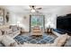 Cozy living room with a ceiling fan, plush seating, and a sliding glass door to the backyard at 638 Nannyberry Ln, Concord, NC 28025