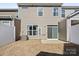 Backyard showing a gray townhouse, a small lawn, a fenced-in yard, and a patio at 6450 Keeton Ln, Harrisburg, NC 28075