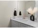 Bathroom with white vanity, countertop, modern faucet, decorative vase and wall mirror at 6450 Keeton Ln, Harrisburg, NC 28075