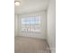 Bright bedroom featuring a neutral carpet, light walls, and a window with blinds at 6450 Keeton Ln, Harrisburg, NC 28075