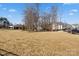 Community dog park featuring open grass and shade trees with nearby townhomes at 6450 Keeton Ln, Harrisburg, NC 28075