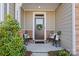Charming front door with wreath, flanked by chairs, welcomes guests to the inviting home at 6450 Keeton Ln, Harrisburg, NC 28075