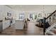 Open-concept living room features hardwood floors and flows into a modern kitchen with stainless steel appliances at 6450 Keeton Ln, Harrisburg, NC 28075