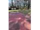 View of the backyard with an outdoor garage and red patio area at 6520 Farmway Pl, Charlotte, NC 28215
