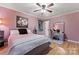Bedroom featuring a decorative mirror, wood-look floors, ceiling fan, and pink walls at 6721 Old Post Rd, Charlotte, NC 28212