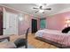 Cozy bedroom with wood-look floors, pink walls, ceiling fan and decorative moon wall art at 6721 Old Post Rd, Charlotte, NC 28212