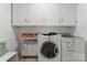 Bright laundry room with white washer and dryer, cabinets, and tiled flooring at 6721 Old Post Rd, Charlotte, NC 28212