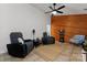 Comfortable living room featuring reclining chairs, a ceiling fan, and a unique wood-paneled wall at 6721 Old Post Rd, Charlotte, NC 28212
