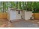 Exterior shot of shed features wood siding, gravel base, and a new door at 6721 Old Post Rd, Charlotte, NC 28212