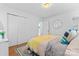 Bedroom featuring a bright yellow throw, hardwood floors and a view into the en suite bathroom at 6914 Idlewild Rd, Charlotte, NC 28212