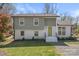 Inviting two-story home featuring gray and white brick exterior, lush landscaping, and a bright green front door at 6914 Idlewild Rd, Charlotte, NC 28212