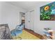 View of the home office showcasing the yellow rug, artwork and a glimpse into an adjoining bedroom at 6914 Idlewild Rd, Charlotte, NC 28212