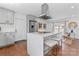 Bright kitchen featuring gray cabinets, stainless steel appliances, and a center island with a breakfast bar at 6914 Idlewild Rd, Charlotte, NC 28212