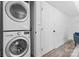 Modern laundry area featuring a stacked washer and dryer unit near an enclosed door at 6914 Idlewild Rd, Charlotte, NC 28212