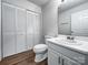 Clean bathroom with wood-look flooring, white vanity, and large mirror at 775 Bridgewood Dr, Rock Hill, SC 29732