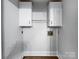 Neutral laundry room with upper storage cabinets and hardwood floors at 775 Bridgewood Dr, Rock Hill, SC 29732