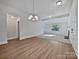 Open-concept living room with fireplace, modern chandelier, and hardwood flooring at 775 Bridgewood Dr, Rock Hill, SC 29732