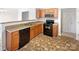 Kitchen featuring wood cabinets, dark countertops, a black oven, a microwave, and a double stainless steel sink at 8005 Mcgarry Trl, Charlotte, NC 28214